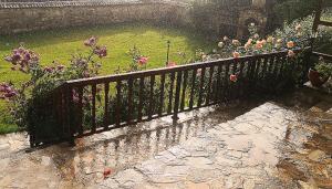 a black fence in a garden with flowers at къща за гости villa Jurta in Avren