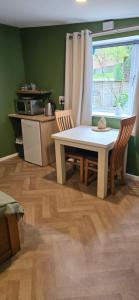 a kitchen with a table and chairs and a window at furnace halls in Taffs Well