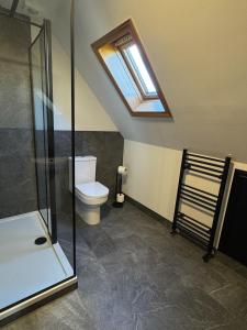 a bathroom with a toilet and a skylight at Wallace Lodge in Crieff +57 photos
