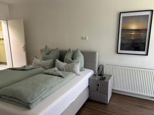 a bedroom with a bed with a picture on the wall at Ferienwohnung Calluna in Buchholz in der Nordheide