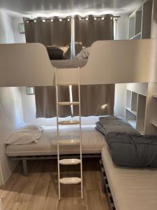 two bunk beds with a ladder in a room at Mobil-home val de durance in Cadenet
