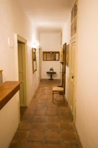 a hallway with a table and a chair in a room at BIANCA ROOMS in Noto +30 photos