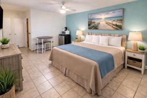 a bedroom with a large bed and a table at Beach Colony Motel in Wildwood Crest +38 photos