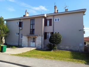 a large white house with a grass yard at Apartmani Nena i Ilka in Pula