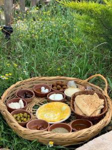 a basket filled with different types of food in the grass at أكواخ الهدهد in Ajloun