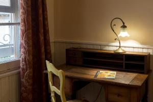 a desk with a lamp and a book on it at Mia Casa in Arles +3 photos