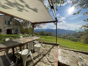 a wooden table and chairs with a view of mountains at La Lupa e l'Orso B&B in Berceto
