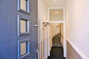 a hallway with a blue door and stairs at Ben Shea Smart Home in Dufftown