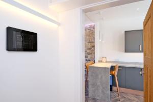 a kitchen with a table and a tv on the wall at Ben Shea Smart Home in Dufftown