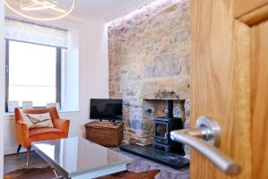 a living room with a stone wall with a fireplace at Ben Shea Smart Home in Dufftown +39 photos