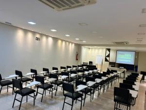a large room with chairs and a projection screen at Hotel Palace Santarém Brasil in Santarém