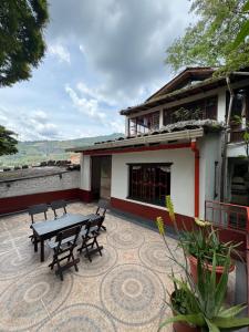 a patio with a table and benches in front of a house at Hospedaje Casa Renasiente - Guest house in Cali