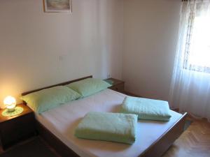 1 dormitorio con 2 almohadas en Apartments Karuso, en Kampor