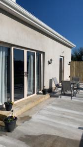 a patio with glass doors and benches on a house at Lakeside cottage retreat in Belcoo