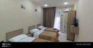 a hotel room with two beds and a television at Motel La Casbah in Constantine