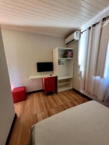 a small room with a desk and a television at Pousada Casa Hospedaria in Paraty