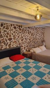 a bedroom with two beds and a stone wall at Casa Isabel in Póvoa dos Mosqueiros