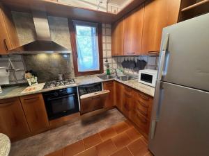 a kitchen with wooden cabinets and a stainless steel refrigerator at La Casa Gialla in Caorle