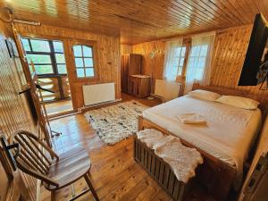 a bedroom with a bed in a wooden room at Cabana din Tei, 5 Camere si Semineu, Costisata, Dambovita in Costişata