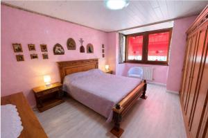 a bedroom with pink walls and a bed and a window at La Casa Gialla in Caorle