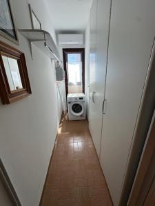 a hallway with a washing machine in a room at La Casa Gialla in Caorle