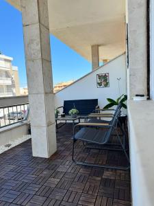 a patio with a table and chairs on a balcony at Mister House in Fiumicino