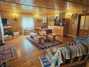 a living room with wooden walls and a wooden floor at Cabana din Tei, 5 Camere si Semineu, Costisata, Dambovita in Costişata