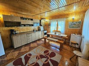 a kitchen with wooden floors and a wooden ceiling at Cabana din Tei, 5 Camere si Semineu, Costisata, Dambovita in Costişata