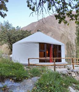 a white yurt with a mountain in the background at Moksha Resort Hunza in Chamangul