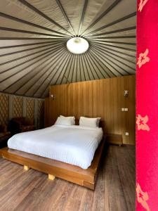 a bedroom with a large white bed with a red wall at Moksha Resort Hunza in Chamangul