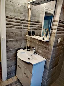 a bathroom with a sink and a mirror at JÁZMIN magán szállás in Makó +11 photos