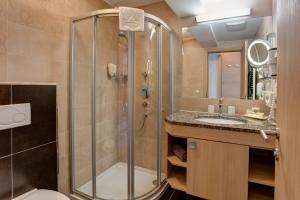 een badkamer met douche, toilet en wastafel bij Hotel Garni - Restaurant Kaminstube in Sankt Anton am Arlberg +46 foto's