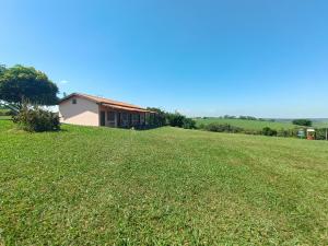 a large grassy field in front of a house at Pousada Xodó in São Pedro