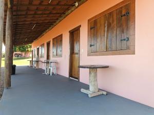 a building with wooden doors and a table on the side at Pousada Xodó in São Pedro