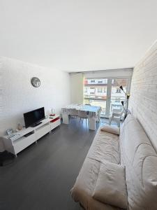 a living room with a couch and a tv and a table at Pies de Mer in Fort-Mahon-Plage