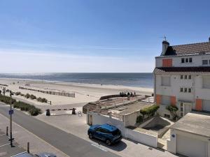 a car parked in a parking lot next to a beach at Pies de Mer in Fort-Mahon-Plage