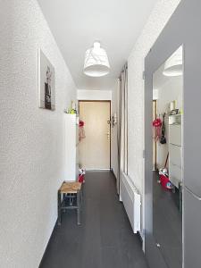a room with a hallway with a table and a refrigerator at Pies de Mer in Fort-Mahon-Plage +2 photos