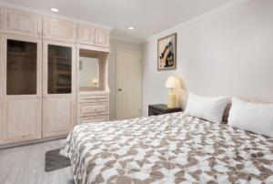 a white bedroom with a large bed and a cabinet at The White Villa in Saint James