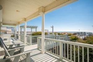 a balcony with chairs and a view of the ocean at Fairwinds by Oak Island Accommodations in Caswell Beach