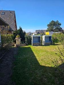 a yard with two blue and white chairs on the grass at Loft Linda in Sylt