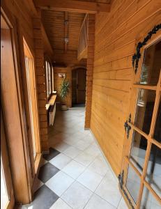 a hallway of a wooden house with a tile floor at Idylle Ferienhaus Ems in Walchum