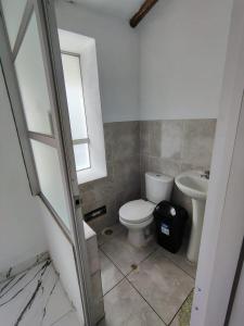 a bathroom with a toilet and a sink at Casa Jardin in Ayacucho