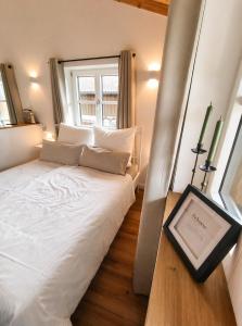 a bedroom with a large white bed with a window at Appartment am Angerweg in Warngau