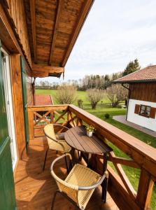 a wooden deck with a table and chairs on it at Appartment am Angerweg in Warngau