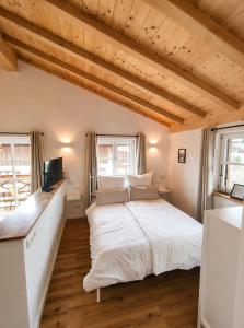 a bedroom with a large white bed and two windows at Appartment am Angerweg in Warngau +8 photos