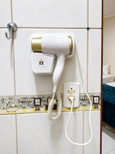 a white phone is hanging on a wall at Hotel Prime Ceaka in Caruaru