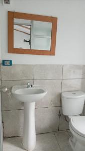 a bathroom with a sink and a toilet and a mirror at Casa Jardin in Ayacucho
