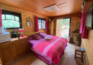 a bedroom with a bed in a wooden cabin at Roulotte de luxe avec piscine partagée à Ramatuelle in Ramatuelle