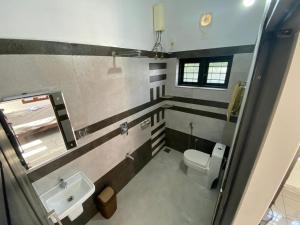 a bathroom with a toilet and a sink at Pappa's Holidays in Sultan Bathery +12 photos