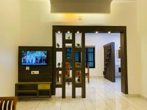 a living room with a tv and a mirror at Pappa's Holidays in Sultan Bathery